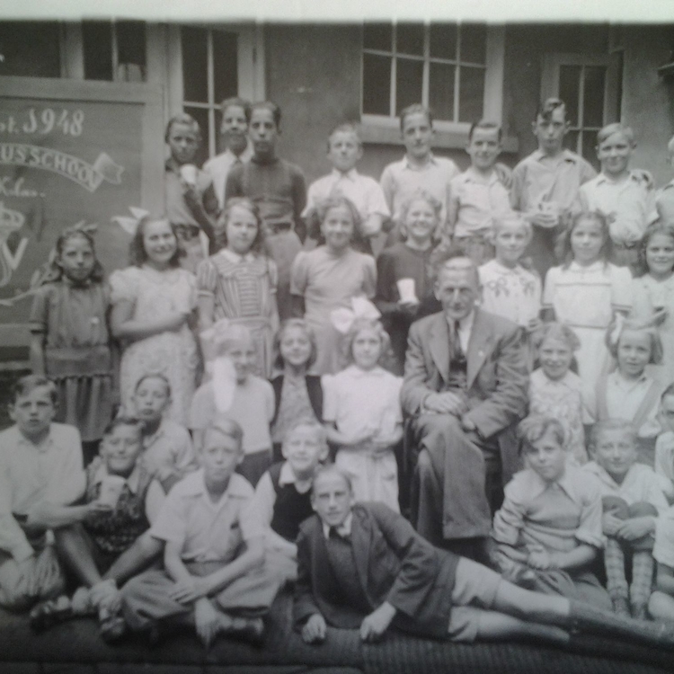 Pontanusschool 1948 Anna zit achter de linkerschouder van Meester van Ommen: 'met twee strikjes op mijn jurk en natuurlijk vlechtjes'. 