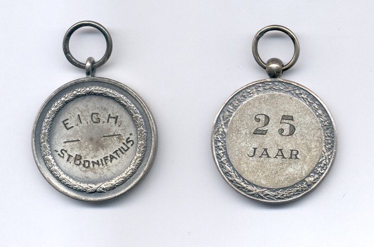 Medailles1 De andere kant van beide medailles: links voor 12,5 jaar en rechts voor 25 jaar trouwe dienst. 