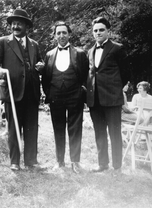 Samuel Henri Englander, bariton-solist Jo Rabbie en koorzanger Barend Levie Muller (?) naast elkaar staand in een park (in Amsterdam ?), ca. 1938-1940. Bron: JCK.   