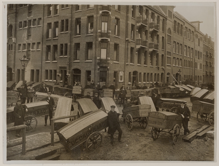 Tolstraat, hoek Toldwarsstraat (ca. 1915) met bakkerskarren van de Algemene Arbeiders Coöperatie De Dageraad (opdruk op de karren). Bron: Beeldbank SAA  