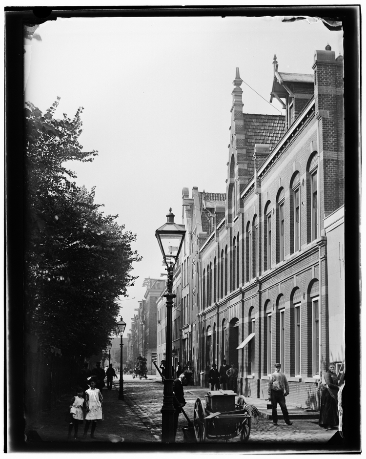 Valckenierstraat gezien naar Weesperplein. Rechts: werkplaats Amsterdamsche Omnibus Maatschappij (AOM) met onder meer een wagenmakerij, een smederij, een tekenkamer enzovoort. Architect: G.B. Salm, 1882, foto uit ca. 1890 door Jacob Olie.   