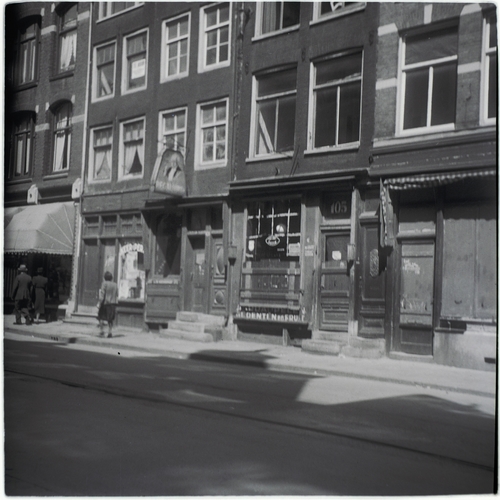 Weesperstraat 99-107 in ca. 1943. Straatbeeld met grotendeels leeggehaalde woningen en winkels na deportatie van de Joodse bewoners en eigenaren. Bron: archief Jaap Kaas (vervaardiger), SAA.  