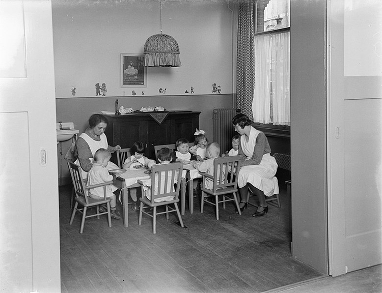 Tehuis Annette: Verzorgsters van het tehuis Annette - in uniform en schort - helpen de peuters bij het eten. Bron: wikimedia Commons, oorspr. 1932  