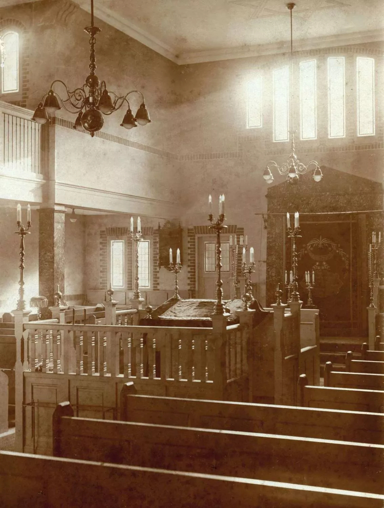 Interieur van de Synagoge, gezien naar de ingang. Datering zou 1913 zijn, onbekende vervaardiger uit de collectie van Het Leven (licentie publiek domein). Gevonden via: “Amsterdam op de Kaart.nl”.  