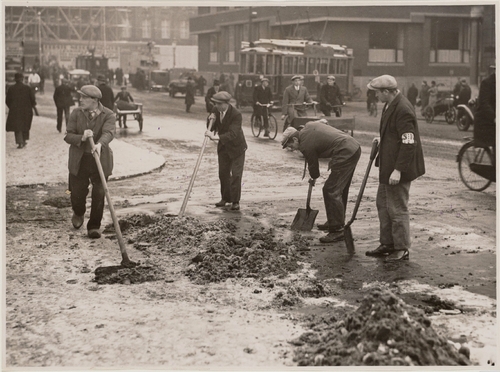 Sneeuwruimen in de Raadhuisstraat met rechts ingang Spuistraat, in 1931. Bron: Ver. Fotobureaux N.V., SAA  