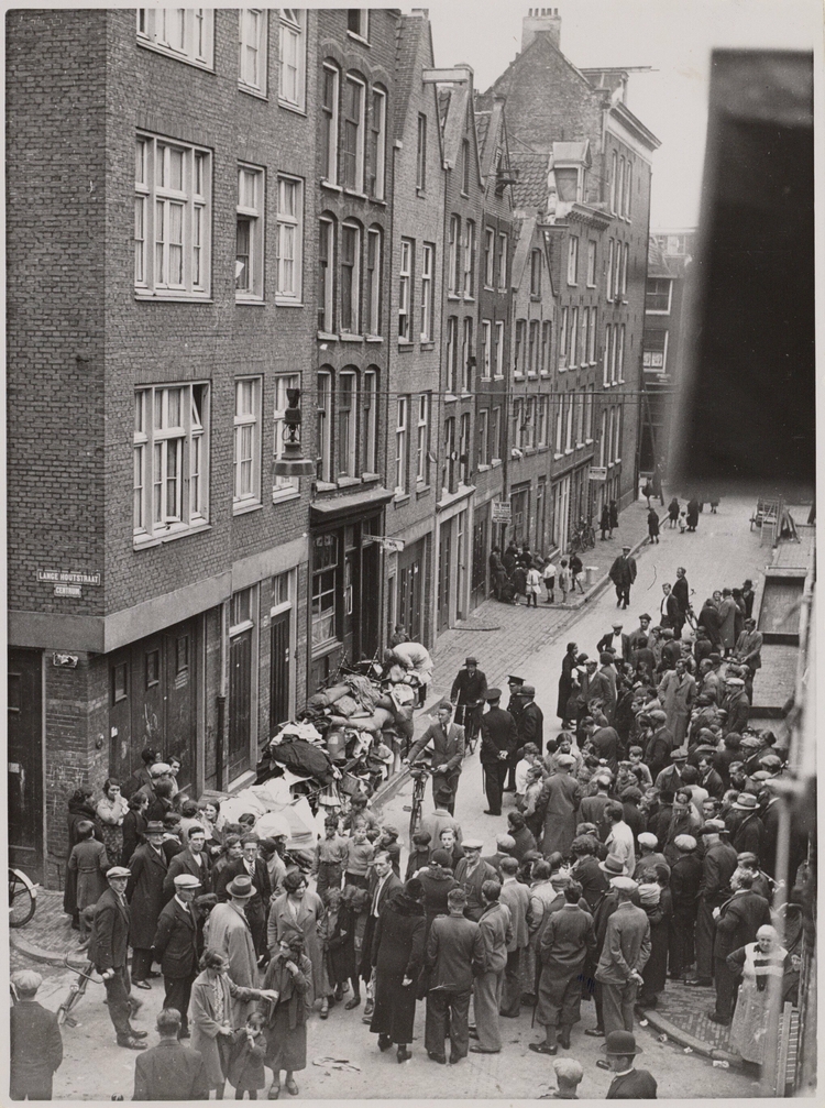 Foto van de Korte Houtstraat 21-23 met rechts de Zwanenburgerstraat. Huisraad op straat gezet wegens huurschuld in september 1936. bron: Polygoon bij SAA  